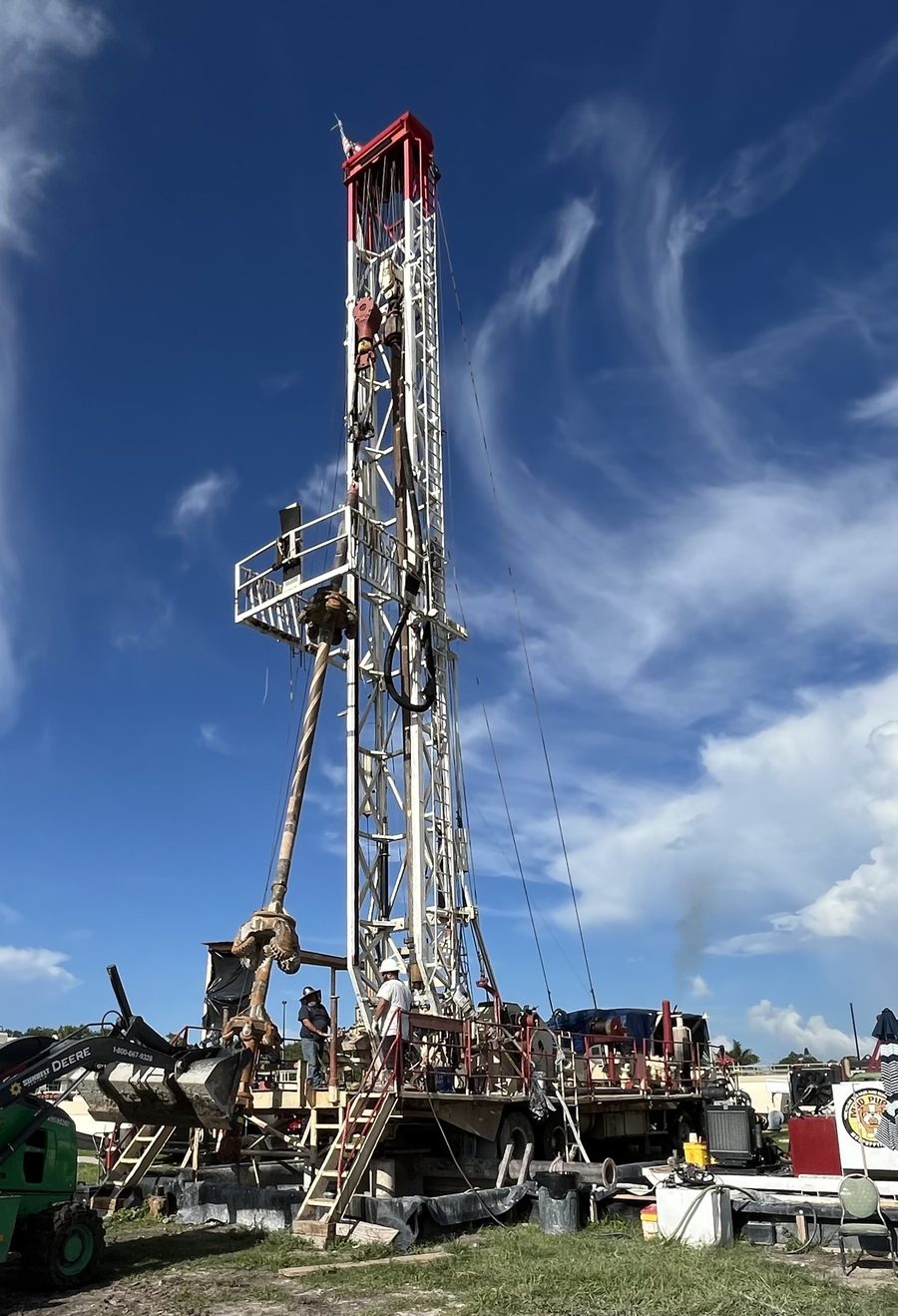 Drilling rig at an aquifer recharge well site, seen from the ground against a blue sky