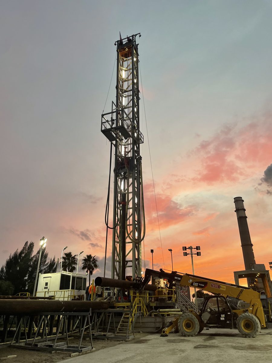 Drilling rig lit against a sunset at the TECO Big Bend injection well site
