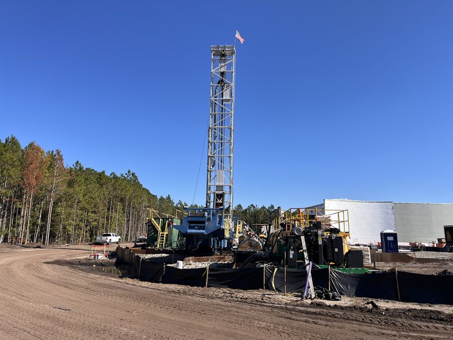 Drilling rig standing over a Class I injection well site under a clear sky